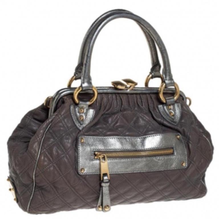 Questo modello di Marc Jacobs ha un esterno trapuntato grigio realizzato in pelle e impreziosito da finiture dorate. Questa elegante borsa Stam presenta una chiusura superiore kiss-lock che si apre su un interno in tessuto e doppi manici superiori.