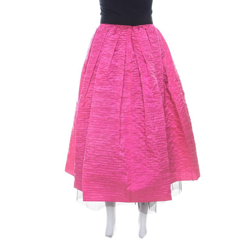 Gorgeous in details and high on appeal, this maxi skirt is from the house of Marc Jacobs. It is made from quality fabrics and designed with a crinkled overlay. This hot pink creation will look perfect with a plain top and flats or strappy