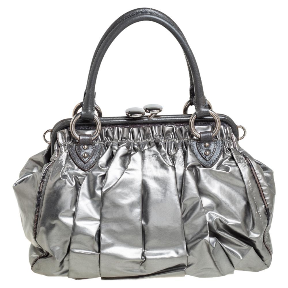This Marc Jacobs design has a grey quilted exterior crafted from leather and enhanced with silver-tone hardware. This elegant Stam bag features a kiss-lock top closure that opens to a fabric and leather interior, dual top handles, and a removable