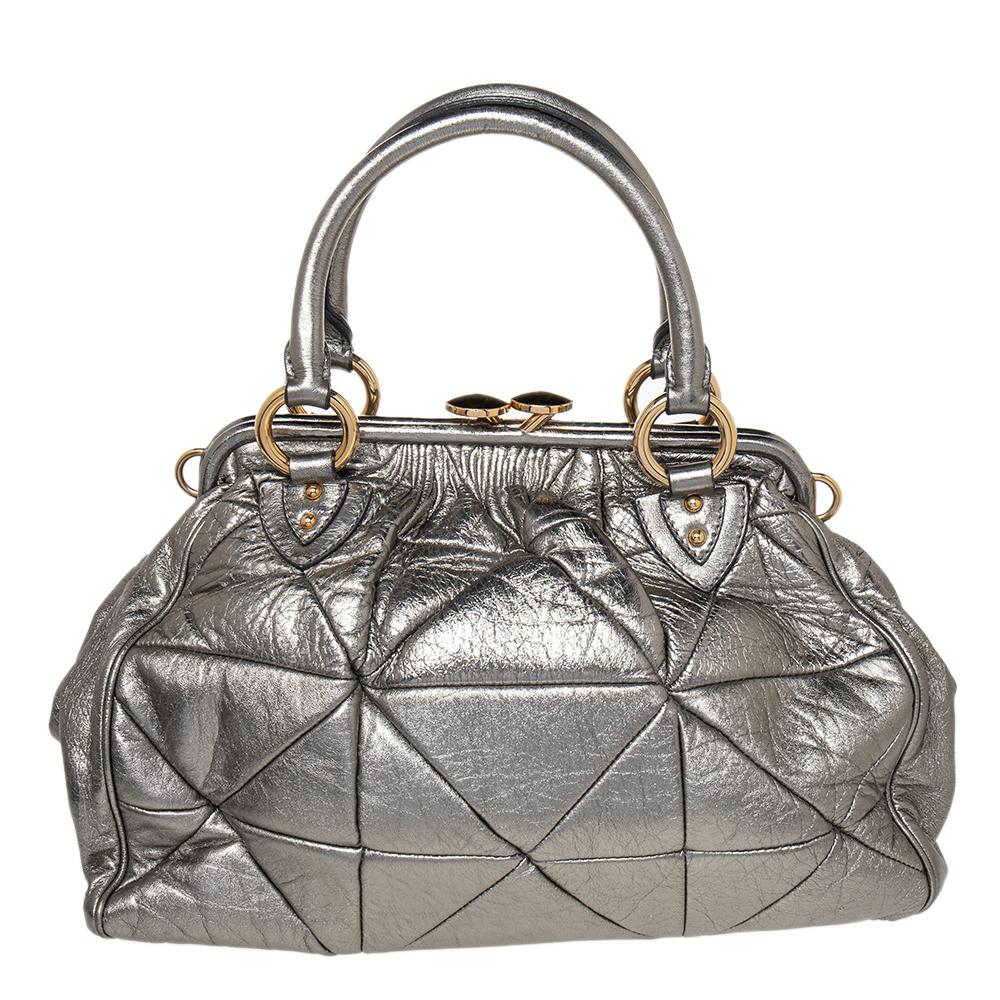 This Marc Jacobs design has a metallic quilted exterior crafted from leather and enhanced with gold-tone hardware. This elegant Stam bag features a kiss-lock top closure that opens to a fabric interior, dual top handles, and a removable chain that
