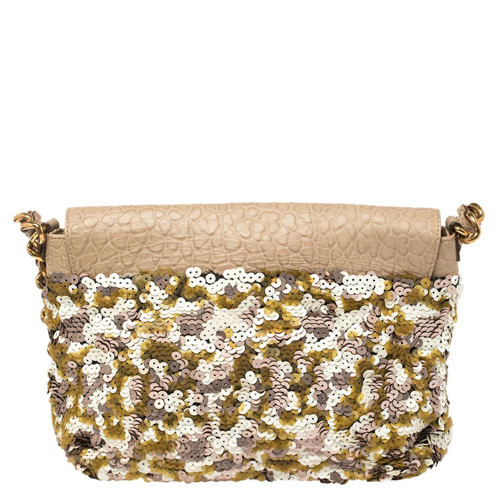 One cannot go wrong with a piece like this Marc Jacobs handbag. This striking piece has been crafted from leather and multicolored sequins. The exterior is styled with a front flap that opens to a well-sized satin-lined interior with a zip pocket.