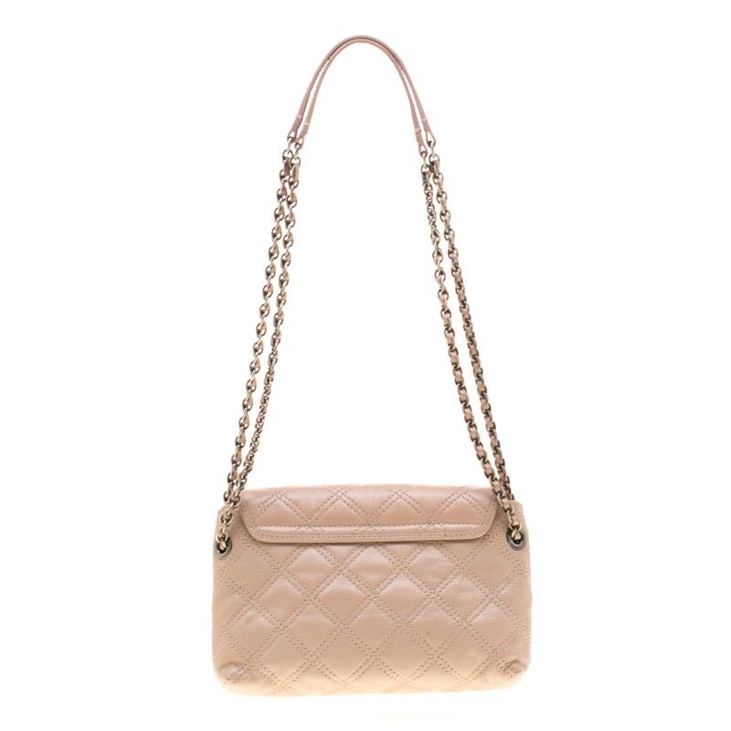 This elegant Marc Jacobs design is simply beautiful. The nude quilted bag is crafted from leather and designed with silver-tone hardware and a flap which secures a spacious fabric interior. This Baroque bag is sure to make heads turn whenever you