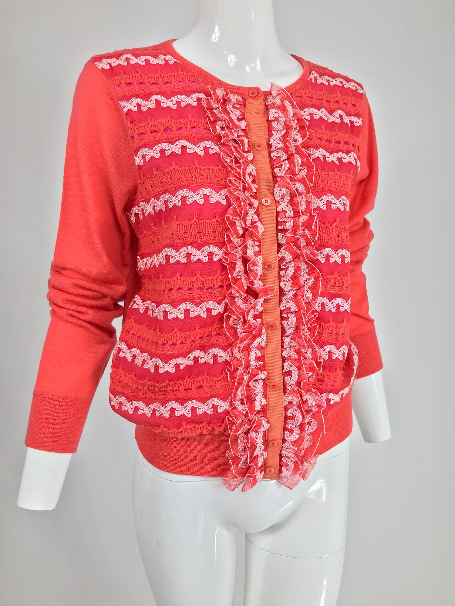 Marc Jacobs orange knit collage cardigan sweater. Long sleeve sweater with ribbed neck, hem and cuffs, the sweater front is done in panels of lace, knit and tulle, with tulle ruffles at either front side, like a collage of sorts. The sweater closes