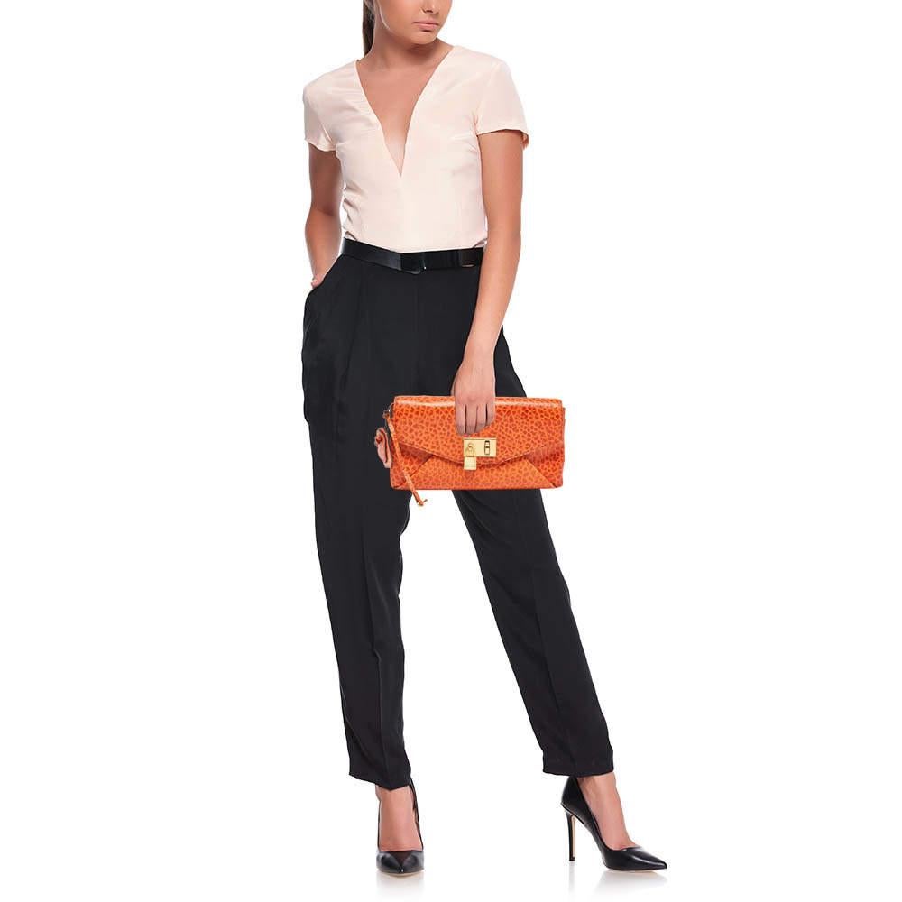 This Marc Jacobs clutch is a creation marked by excellent craftsmanship and refined style. This flap style clutch is crafted with skill and impeccably finished to be a luxurious accessory in your hand.