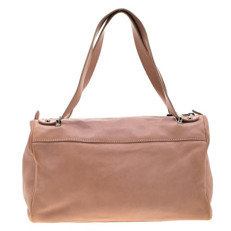 This Boston bag is from Marc Jacobs. Crafted from leather, the peach bag flaunts a zip pocket and dual buckle pockets on the front. It comes with two handles and the top zip closure opens to a suede-lined spacious interior.

Includes: Original