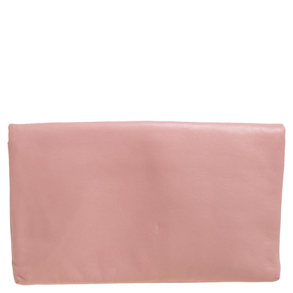 Supporting a contemporary style, this clutch by Marc Jacobs can be a perfect choice for an evening. The exterior is made from leather and comprises of a flap. It features a gold-tone hardware lock with brand detailing. The fabric-lined interior has