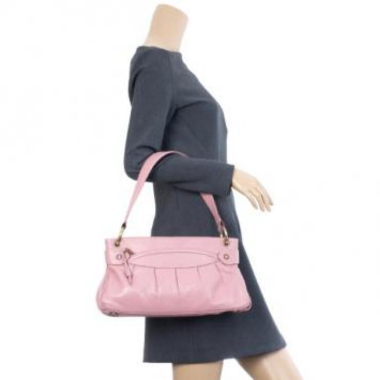 We are in love with this cute and girly Marc Jacobs Lola bag! The exterior features a soft pink calf leather and is fitted with two zip pockets. The interior is lined with red suede and has a single zip pocket and slip pocket. The hardware on Lola