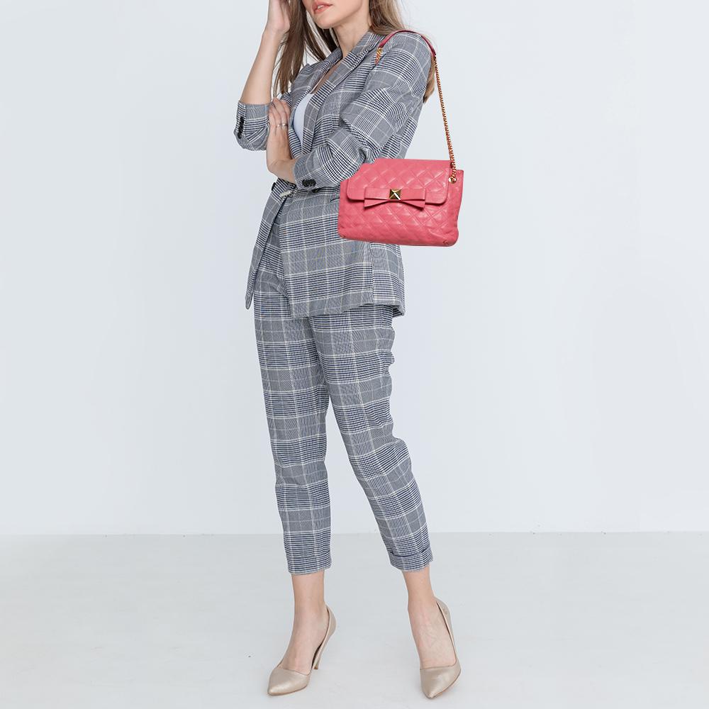 This Marc Jacobs bag will help you put together an easily urbane look. It is crafted from pink quilted leather and features a pretty bow on the front flap. The fabric-lined interior houses two compartments and a zip pocket. The exquisite design of