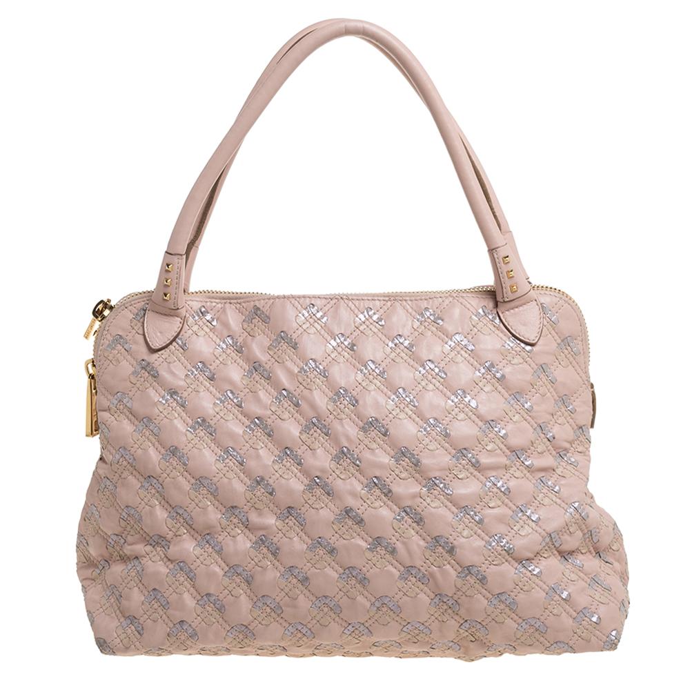 An elegant piece of art, this stylish Marc Jacobs satchel is just what you need to elevate your style quotient. This Memphis Robert Jena bag has a quilted design. It also has leather tassels, gold-tone hardware, and double top handles. Lined with