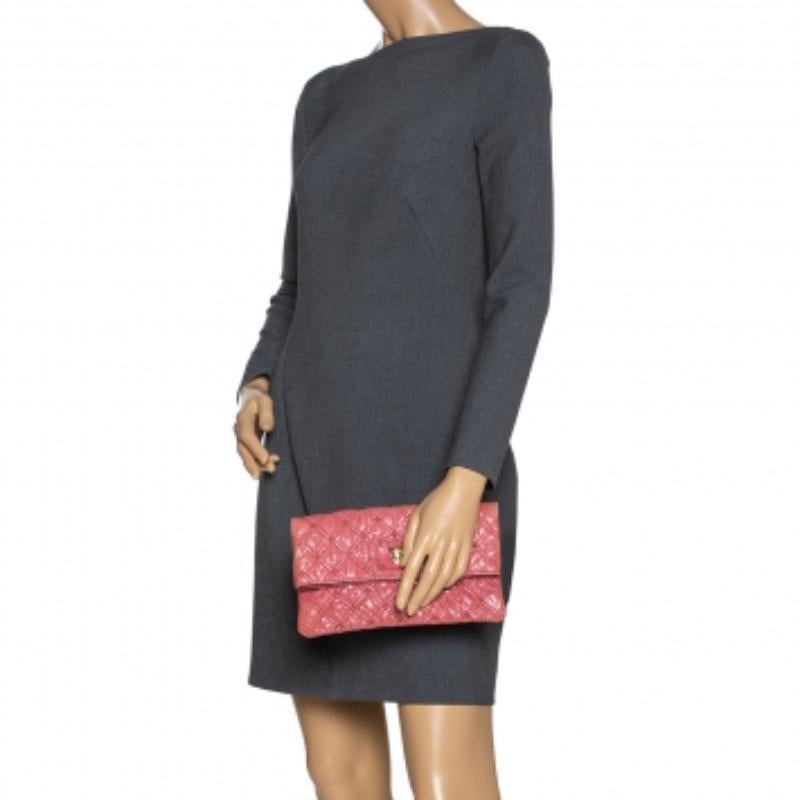 Covered in a timeless quilted pattern, this Eugenie clutch by Marc Jacobs comes in a flap style. It has a pink leather body with stud embellishments, gold-tone lock on the flap, and a fabric interior. Carry this pretty clutch with your evening