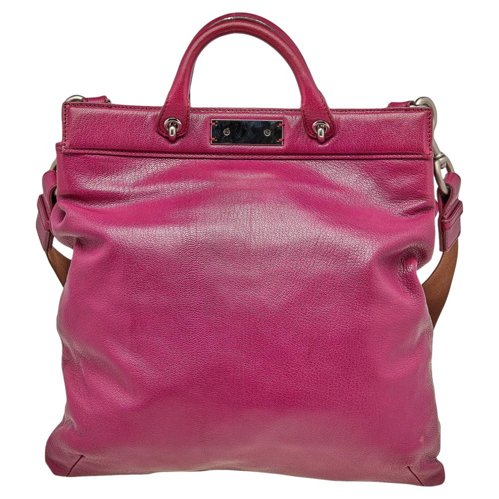 The Robert Duffy bag by Marc Jacobs has a two-in-one design with a sequin-covered pouch added to the front of the main leather tote. The tote has a spacious interior, two handles, a shoulder strap, and twist-lock closure. The front pouch resembles