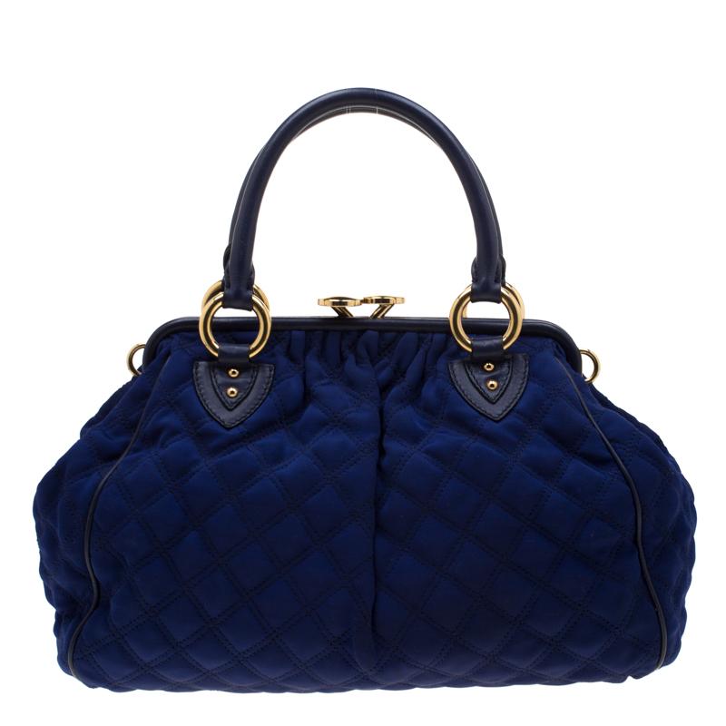 This Marc Jacobs design has a purple quilted exterior crafted from fabric and enhanced with gold-tone hardware. This elegant Stam bag features a kiss-lock top closure that opens to a fabric interior, dual top handles and a removable chain that