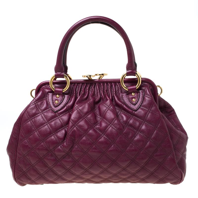 This Marc Jacobs design has a purple quilted exterior crafted from leather and enhanced with gold-tone hardware. This elegant Stam bag features a kiss-lock top closure that opens to a fabric interior, dual top handles and a removable chain that