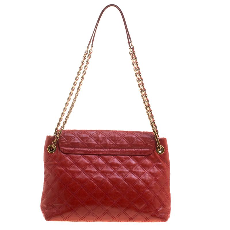 This elegant Marc Jacobs design is simply beautiful. The red quilted bag is crafted from leather and designed with gold-tone hardware and a flap which secures a spacious canvas interior. This bag is sure to make heads turn whenever you swing this