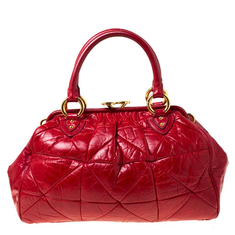 This Marc Jacobs design has a red quilted exterior crafted from leather and enhanced with gold-tone hardware. This elegant Stam bag features a kiss-lock top closure that opens to a fabric interior, dual top handles and a removable chain that