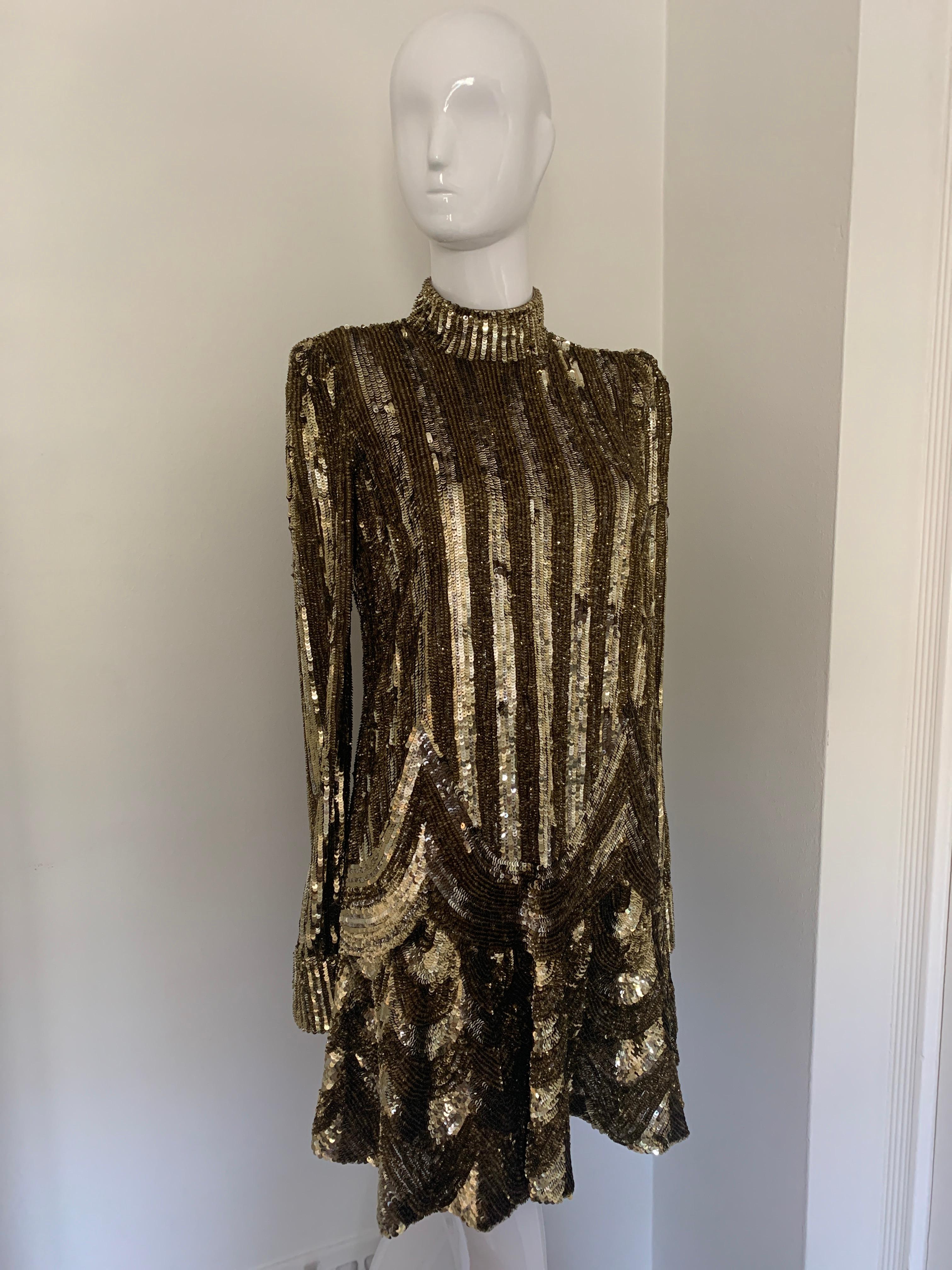 MARC JACOBS SEQUINED MOCK-NECK MINI DRESS
Gold Sequins
Long Sleeve 
Straight Cut with ruffle at the bottom 
Two Shades of gold 
Made in the USA 
Size US 2 

Excellent Condition 

