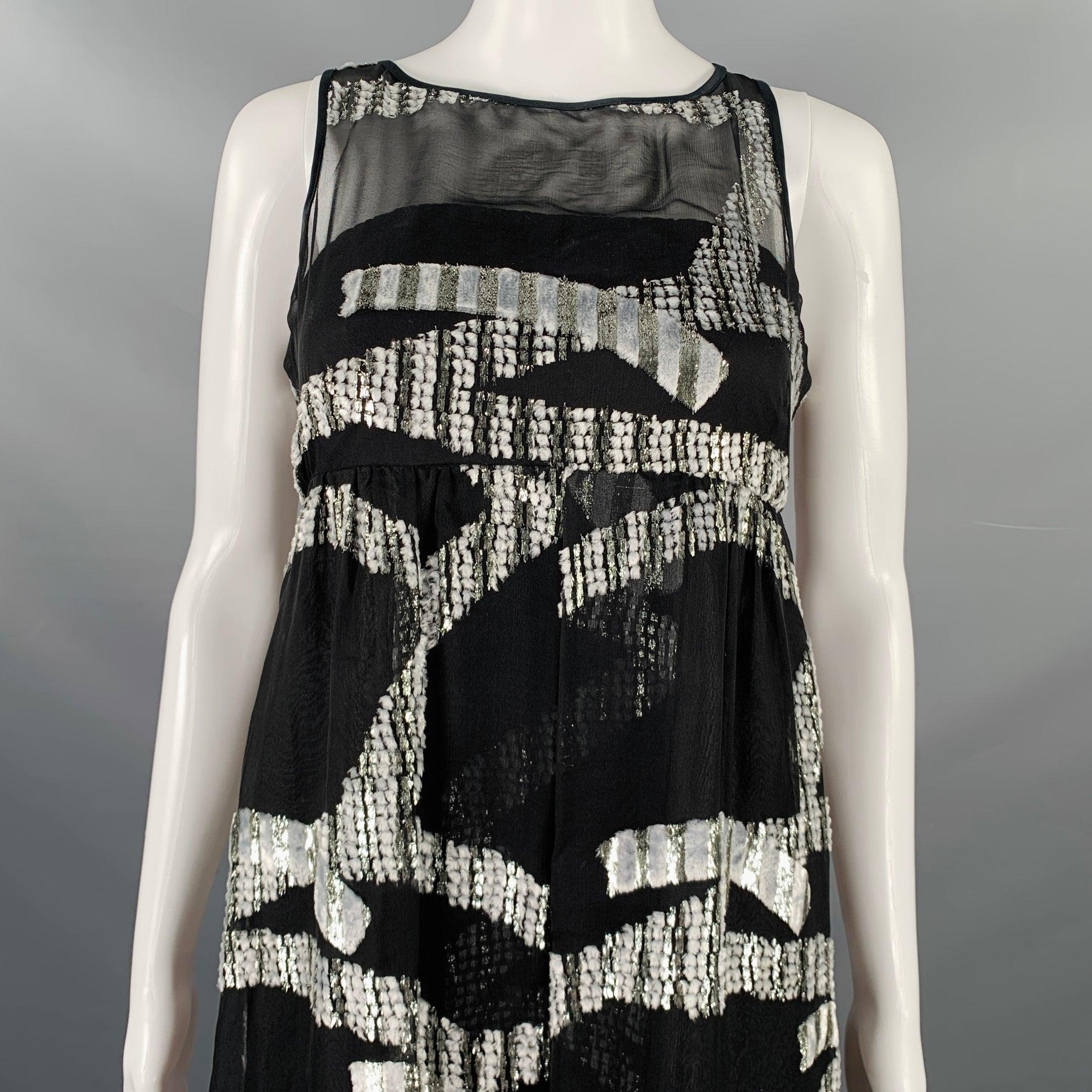 Vestido MARC JACOBS
en un tejido de mezcla de seda en tonos negros y plateados, con un estilo imperio sin mangas, diseño jacquard abstracto, sujetador incorporado con cierre de cremallera en la espalda y cierre de botones en la espalda.Excelente