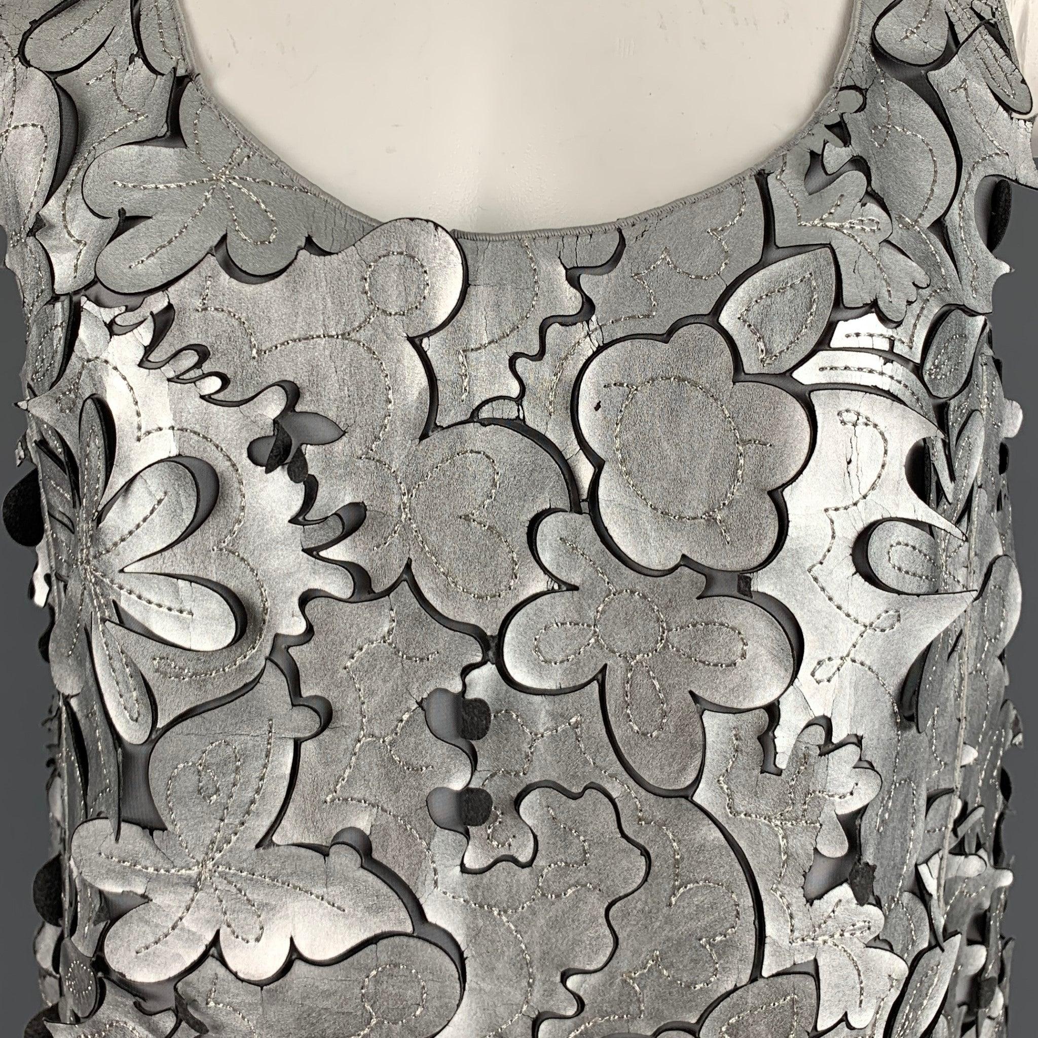 MARC JACOBS dress top
in a silver grey leather fabric featuring laser cut floral design, sleeveless style, and back zipper closure.Good Pre-Owned Condition. Moderate signs of wear. 

Marked:  0 

Measurements: 
 
Shoulder: 12.5 inches Bust: 34