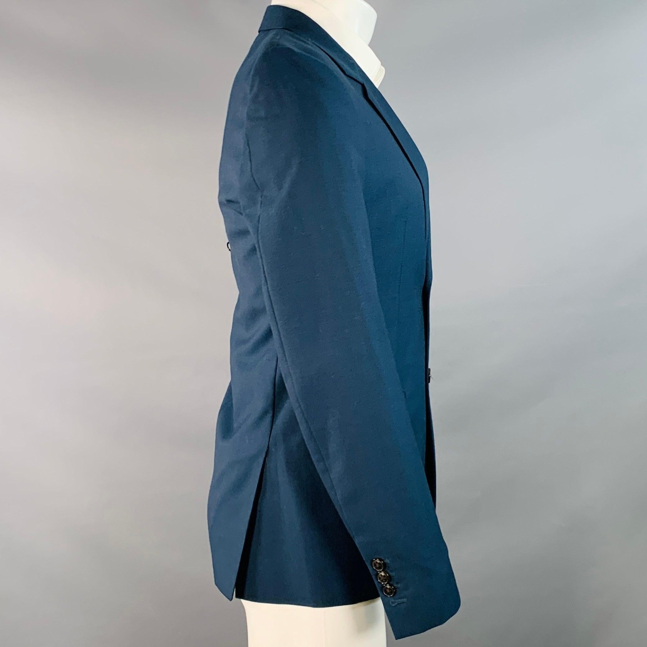 Manteau de sport MARC JACOBS
en laine tissée marine, avec un revers à cran, un dos doublement ventilé et une fermeture à double bouton. Fabriqué en Italie. Très bon état. Petites marques difficilement visibles sur les poignets et le cou. 

Marqué : 