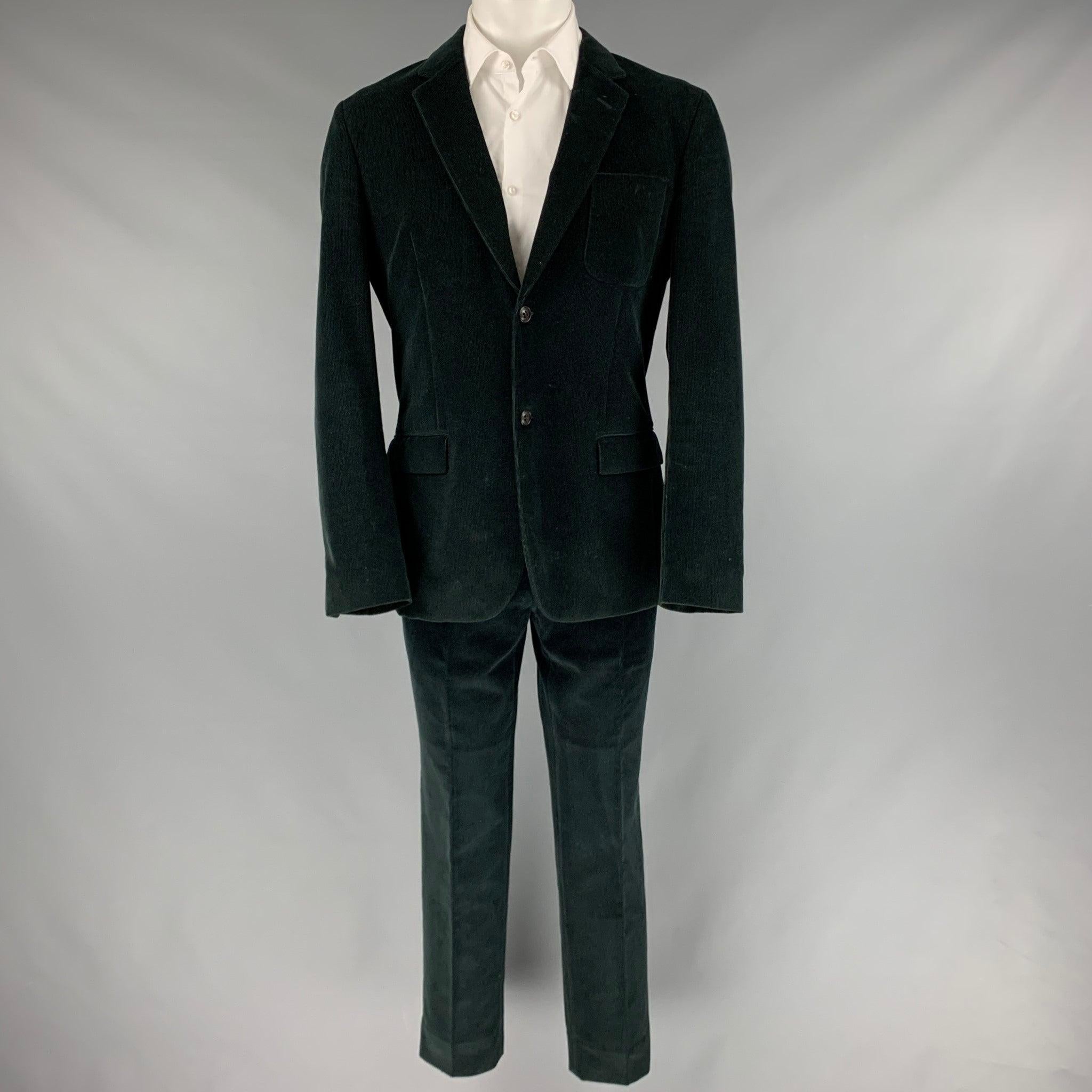 MARC JACOBS suit in a black corduroy cotton with a full liner and includes a single breasted, double button sport coat with notch lapel and matching flat front trousers. Made in Italy. Note: this item may appear to be green in different lighting