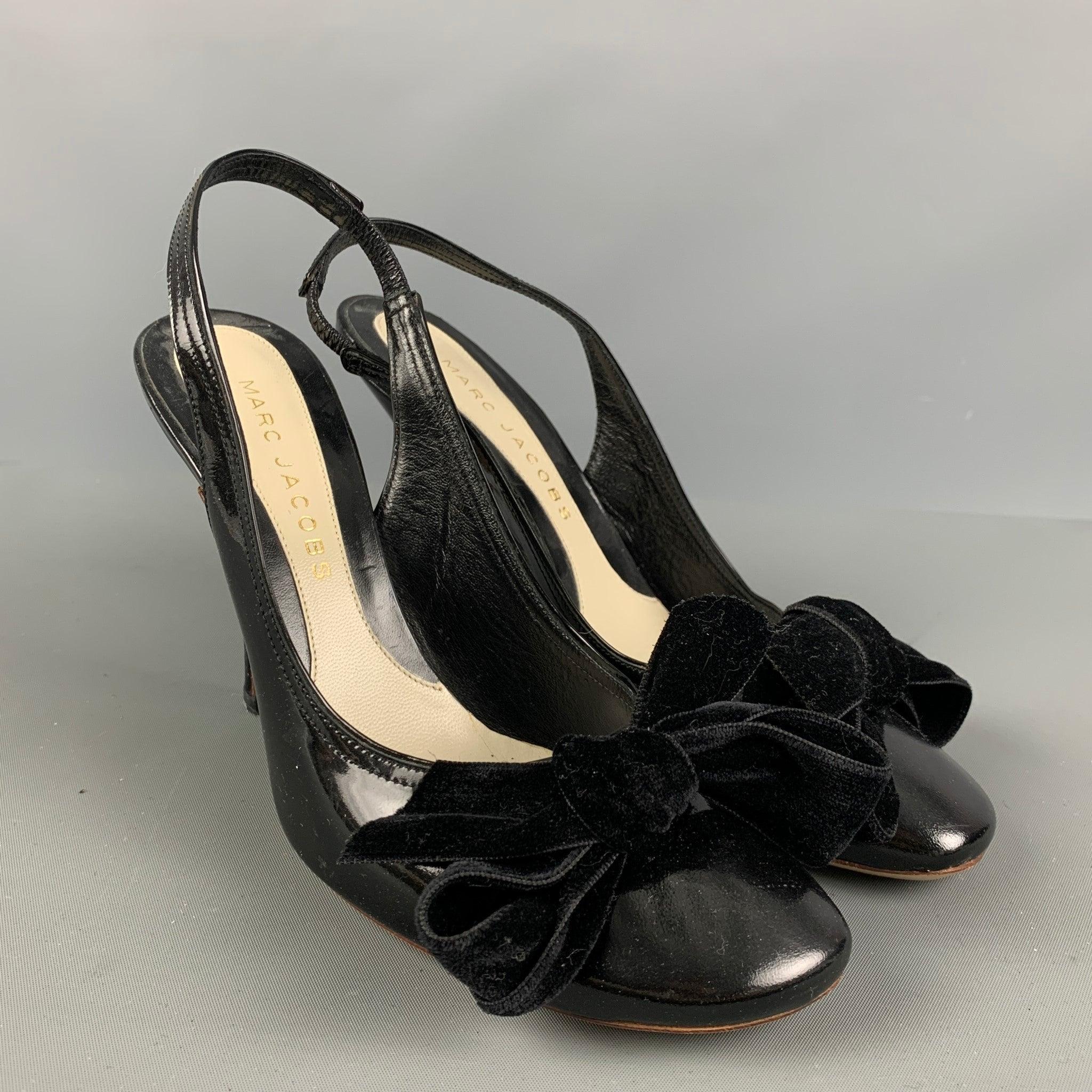 MARC JACOBS pumps comes in a black patent leather material featuring a slingback style, velvet trim bow detail, and a stiletto heel. Made in Italy.Very Good Pre-Owned Condition. As Is. 

Marked:   36 1/2 

Measurements: 
  Heel: 4 inches 
  
  
