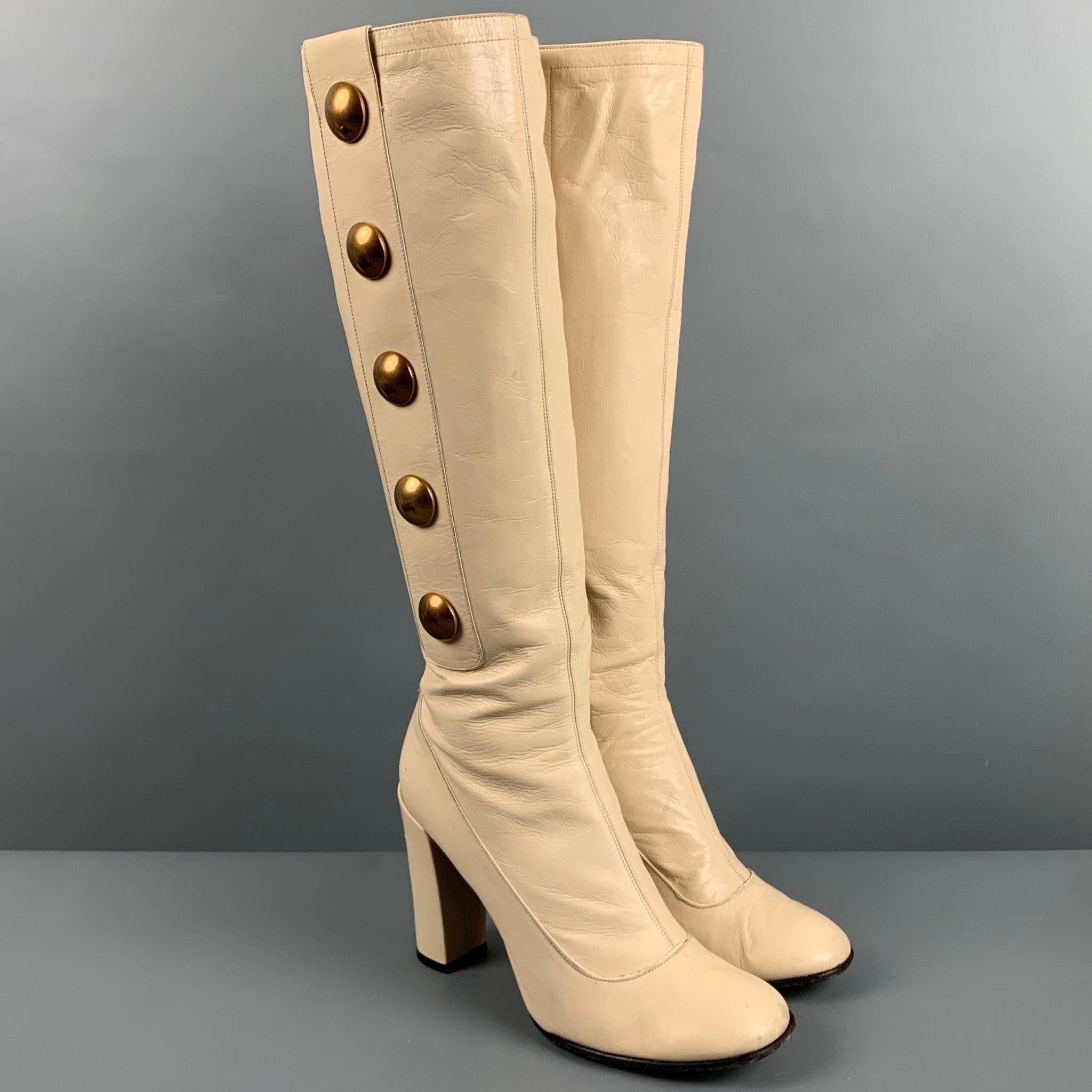 Vintage MARC JACOBS boots
in a cream leather featuring brass tone studs, knee high style, and chunky heel. Made in Italy. Very Good Pre-Owned Condition. Minor signs of wear. 

Marked:   37.5 

Measurements: 
  Length: 8.5 inches Width: 3 inches
