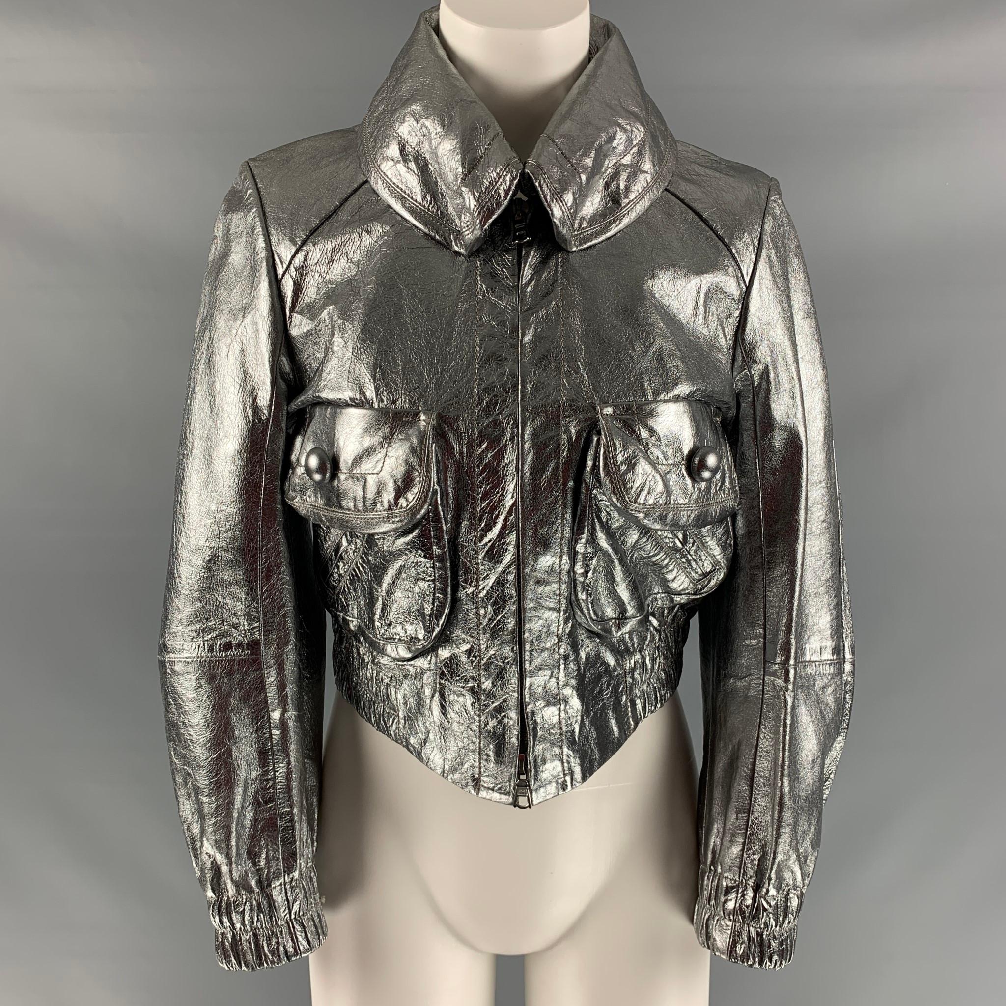 MARC JACOBS cropped jacket comes in silver metallic leather featuring high neck, zip up closure, and two patch with flap pockets at front. Made in USA.

Excellent Pre-Owned Condition.
Marked: 8

Measurements:

Shoulder: 16 in.
Bust: 37 in.
Sleeve: