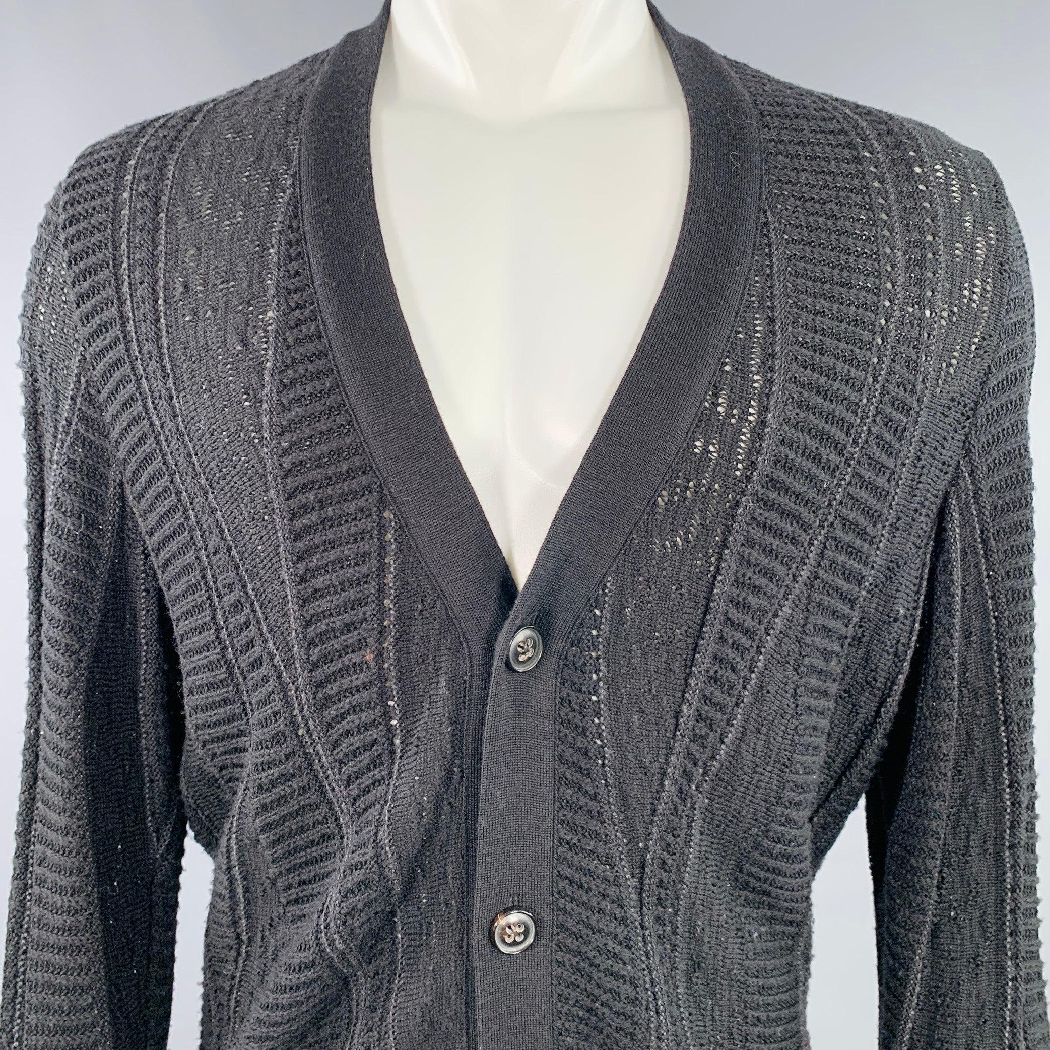 Gilet MARC JACOBS
dans un tricot noir en laine et coton mélangés, avec des motifs mixtes réalisés à l'aide de différentes techniques de tricotage, des manches extra longues et une fermeture à boutons. Fabriqué en Italie. Bon état d'usage. Boulochage