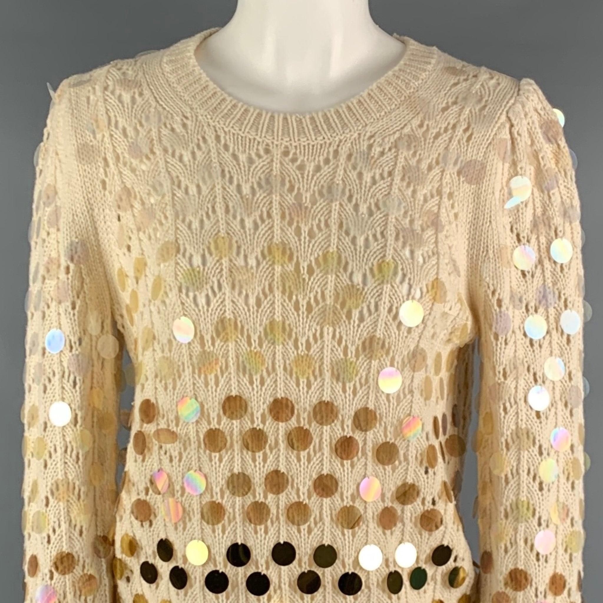 MARC JACOBS sweater
in a cream wool cashmere blend knit featuring payette sequins which ombre from clear to an opaque gold, lace-like see-through knit technique, raised shoulders, and a crew neck.Very Good Pre-Owned Condition. Minor signs of wear on