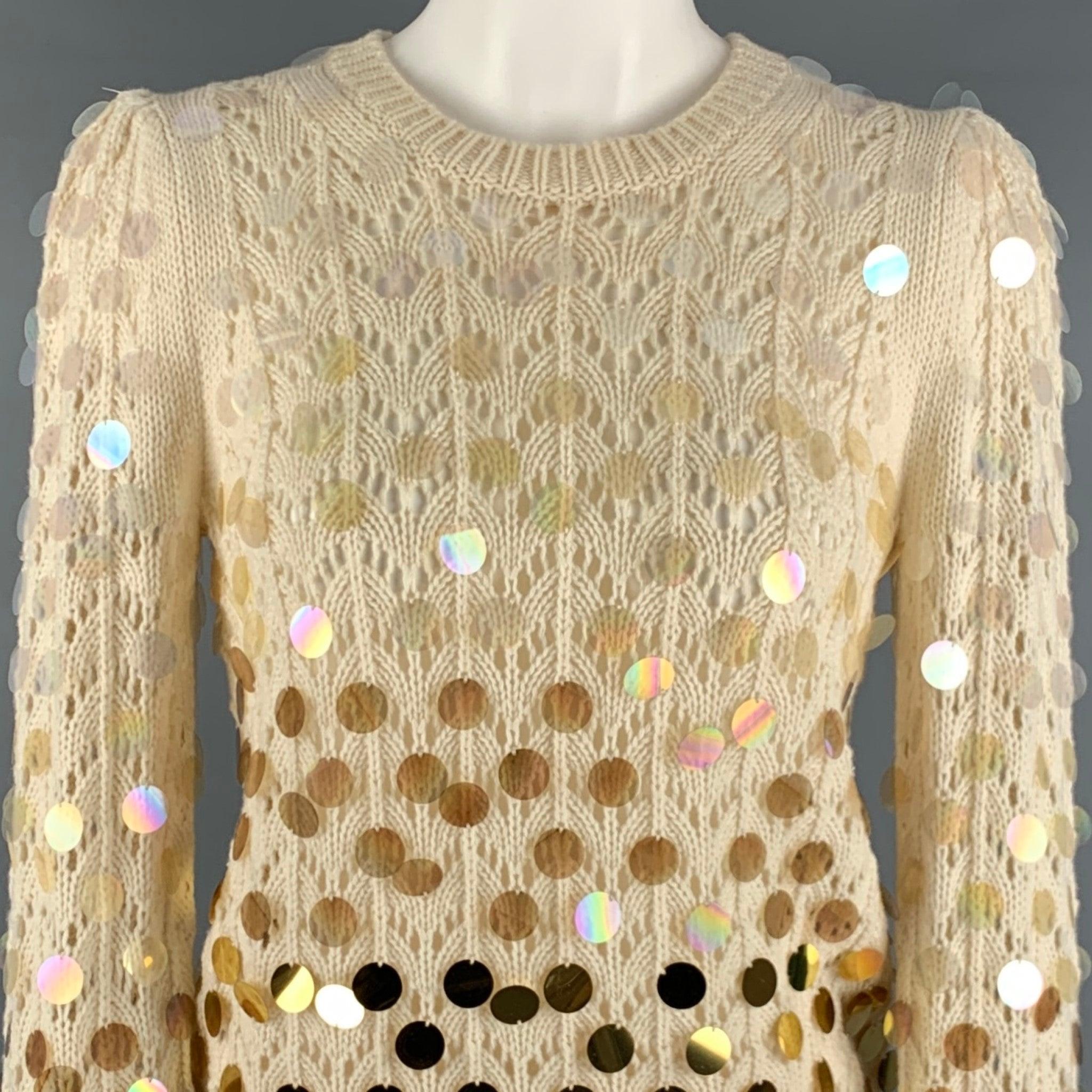 MARC JACOBS Pullover
aus einer cremefarbenen Woll-Kaschmir-Mischung mit Payette-Pailletten, die von klar zu einem undurchsichtigen Gold schillern, spitzenartiger, durchsichtiger Stricktechnik, hochgezogenen Schultern und Rundhalsausschnitt.Sehr