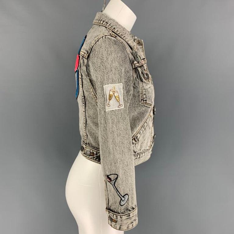 MARC JACOBS jacket comes in a black acid-wash denim featuring a cropped style, pin details, patches throughout, contrast stitching, front pockets, a back embroidered 'paradise' design, and a buttoned closure.
New With Tags. 

Marked:   XS