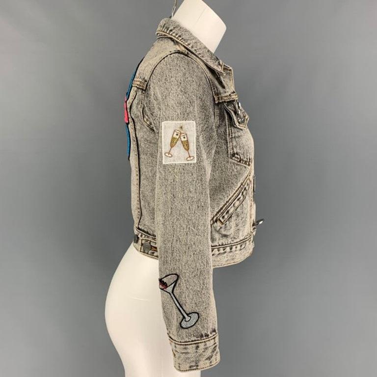 MARC JACOBS jacket comes in a black acid-wash denim featuring a cropped style, pin details, patches throughout, contrast stitching, front pockets, a back embroidered 'paradise' design, and a buttoned closure.
Very Good
Pre-Owned Condition. 

Marked: