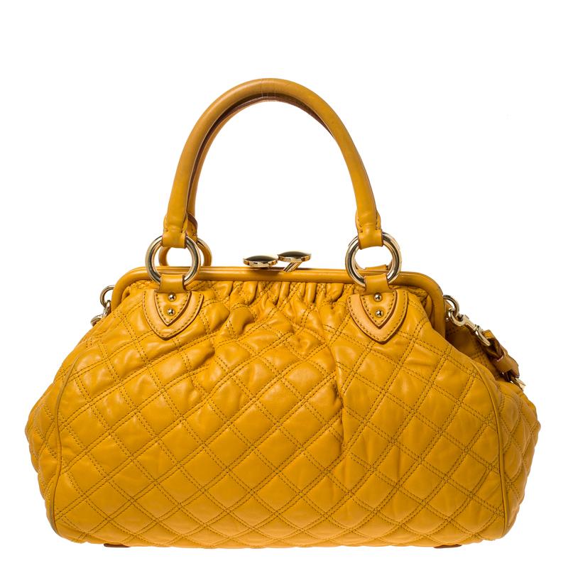 This Marc Jacobs design has a yellow quilted exterior crafted from leather and enhanced with gold-tone hardware. This elegant Stam bag features a kiss-lock top closure that opens to a fabric interior, dual top handles and a removable chain that