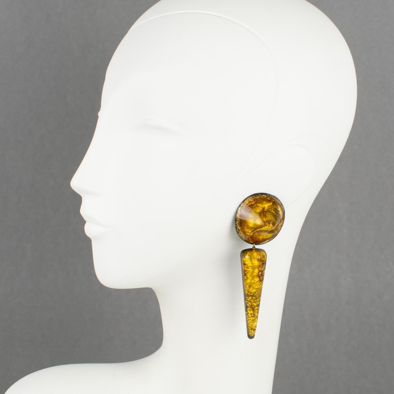 French designer Marc Labat, Paris, designed these stunning oversized resin clip-on earrings in the 1980s. They feature a dangling dimensional geometric shape with a round pyramid and teardrop elements. Each element has a black background base