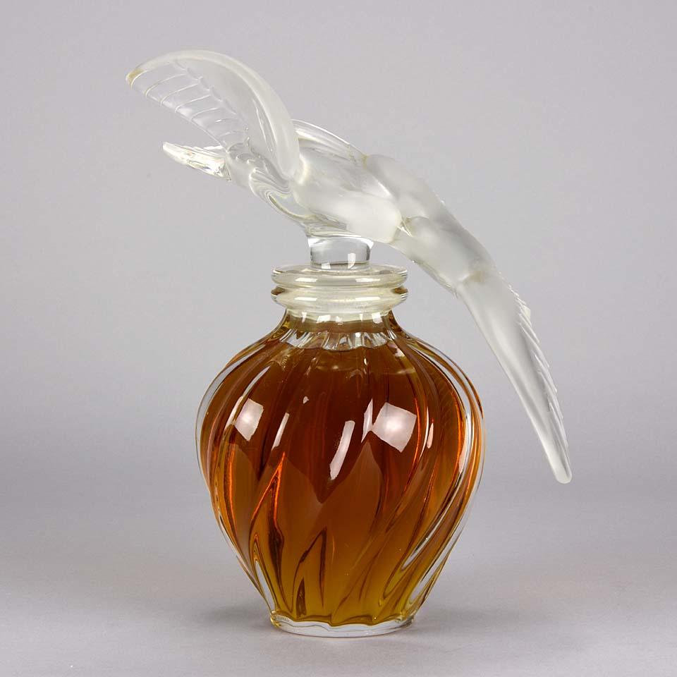 A large and imposing French crystal glass Scent bottle used for display purposes at Fortnum and Masons in the 1960's. The large stopper designed as two intertwining doves in frosted glass and filled with original scent, signed Lalique France around