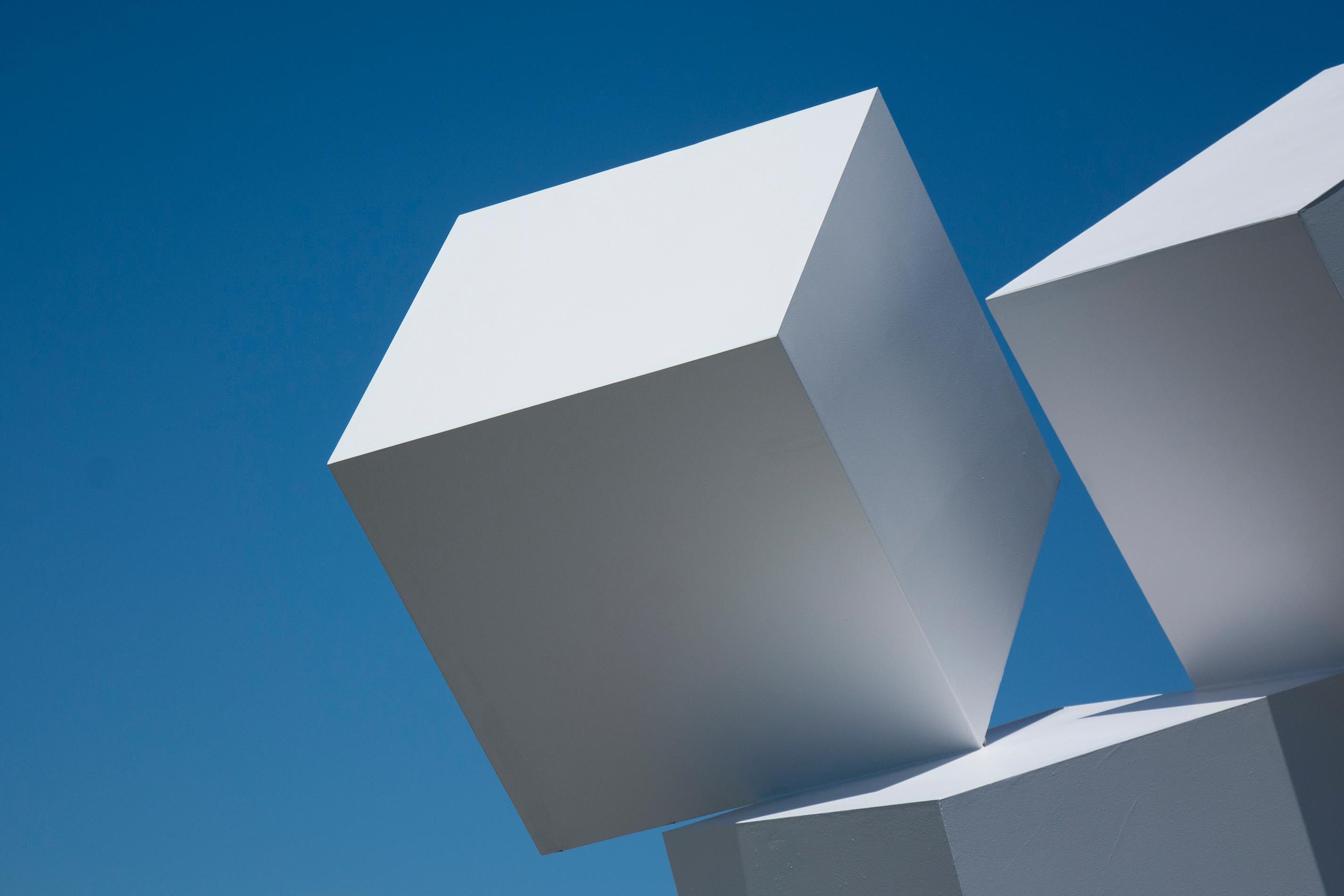 Impossibly balanced, these three white cubes form one monolithic outdoor structure. At night the sides of the cubes appear as free-floating diamonds. This painted, aluminum sculpture is stone white. It is available by commission and titled Chute Des