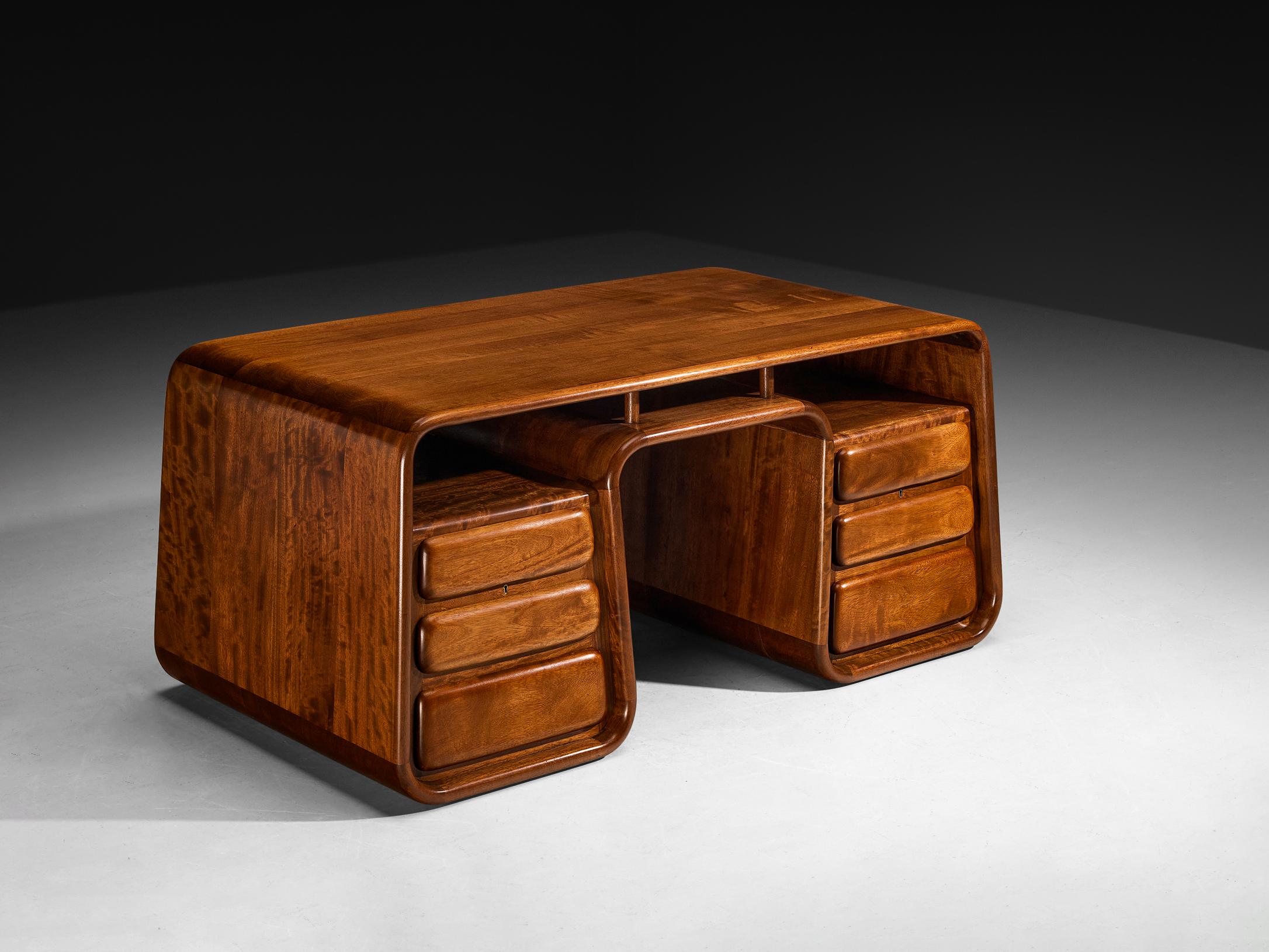 Marc van Rampelberg, bureau autoportant, iroko, Kenya, années 1980. 

Ce bureau autoportant en Iroko massif est fabriqué au Kenya et conçu par le designer belge Marc van Rampelberg. Après avoir voyagé en Afrique pendant de nombreuses années, Van