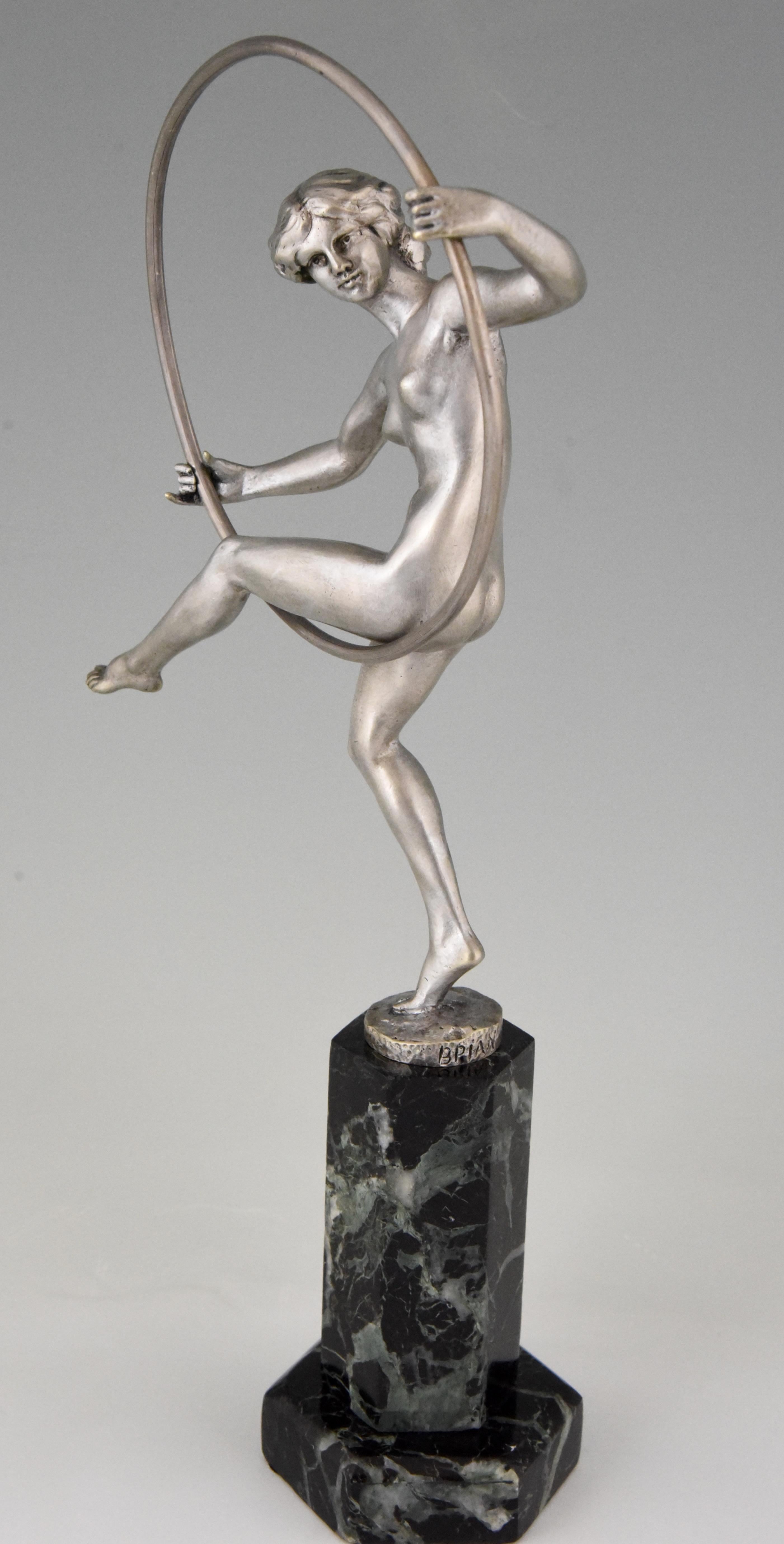 Art Deco bronze sculpture of a nude dancer with hoop. The bronze has a silver patina and stands on a green marble base. The work is signed Briand, pseudonym of Marcel Andre Bouraine, France 1920. 

“Art deco sculpture” by Victor Arwas, Academy.