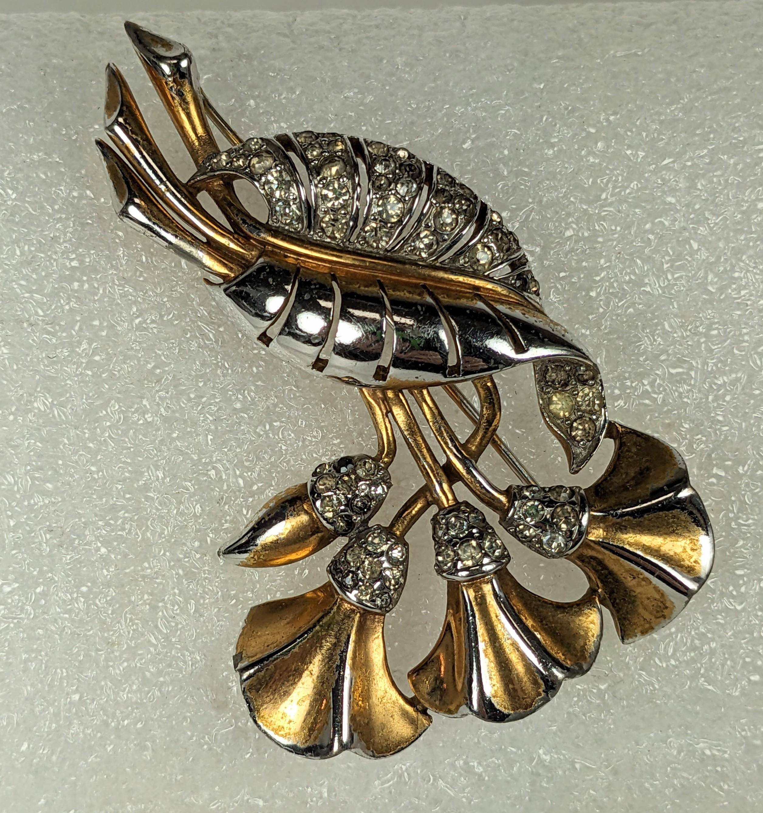 Broche Marcel Boucher Early Lily des années 1930. Lys stylisé en rhodium avec placage or et accents en cristal pave. Le placage d'or est usé sur les parties hautes de la broche et lui donne un aspect bicolore aujourd'hui. 
États-Unis, années 1930.