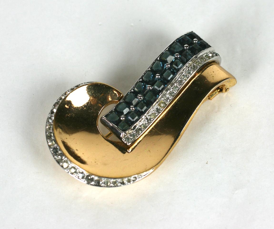 Marcel Boucher Jean Fouquet inspired clip brooch. Of 14 kt gold plate and rhodium base metal, crystal pave and calibre invisibly set faux sapphires.  1930's USA.
Clip back fittings. Excellent Condition.
Length 2.25