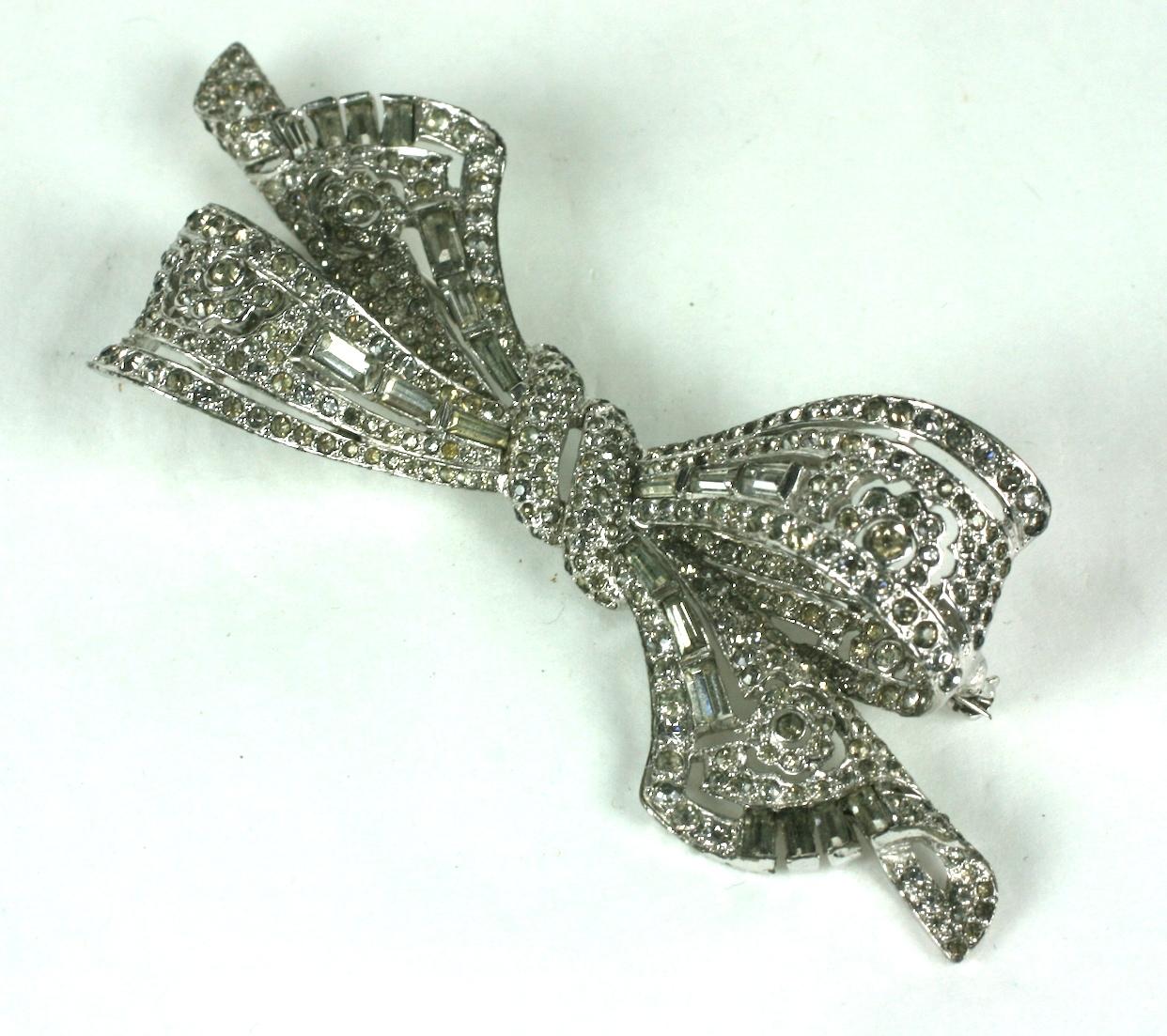 Marcel Boucher crystal pave and baguettes floral bow brooch.  Rhodium plated base metal, crystal rhinestones, pierce work set with rectangular and tapered baguettes.
Signed MB (phrygian cap) 
Excellent Condition Length 3