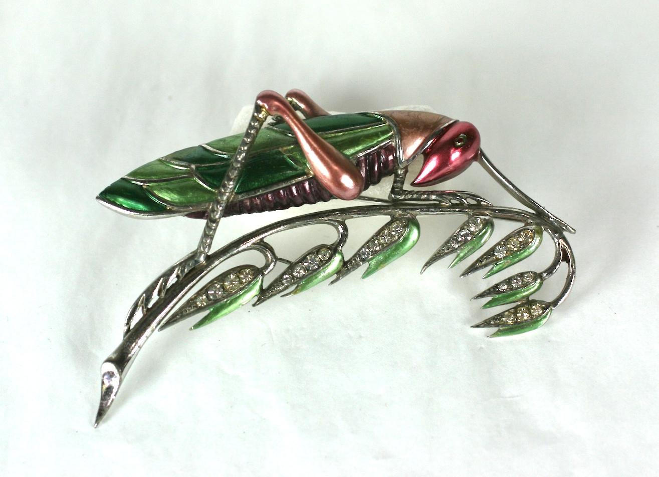 Rare and highly collectible Marcel Boucher large brooch of a pearlized cold enameled grasshopper resting on a wheat grass stalk. 
Rhodium plated base metal, crystal pave rhinestones. 1941 USA. 
Excellent Condition. Length 4