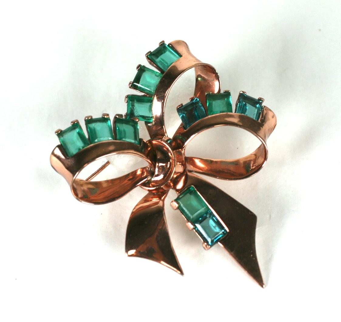 Marcel Boucher retro sterling silver rose gold plate bow knot  brooch. Rectangular cut rectanqular  emerald blue stones are set along the bows edges.  Dated 1945.
Excellent Condition.
Signed MB (phrygian cap), Sterling
Length 3