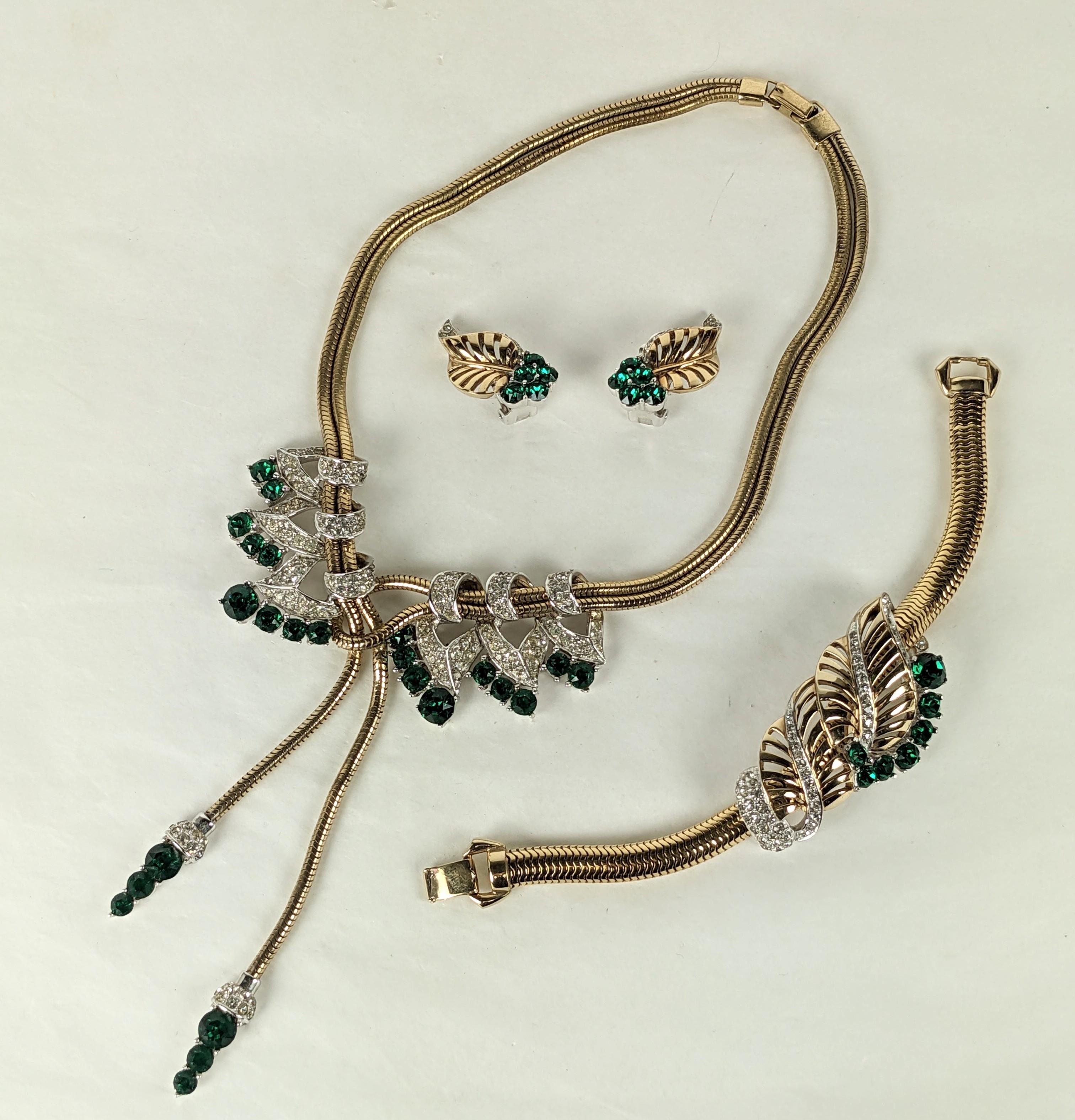 Exceptional Marcel Boucher Retro Emerald Paste Parure from the 1940's. Gas pipe chain used with pave and emerald paste retro motifs. Tassel drop necklace and retro leaf bracelet with matching clip earrings. Early MB mark, 1940's USA.
