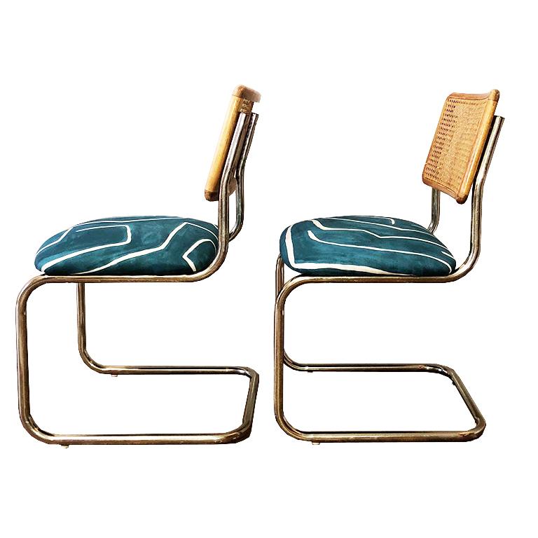 Marcel Breuer style cantilever chairs with cane back and upholstered cushions. Cushions upholstered in Kelly Wearster's teal channel print fabric. Cantilever legs are in a beautiful gold/brass. Cane is in excellent shape. Each chair has 4 small