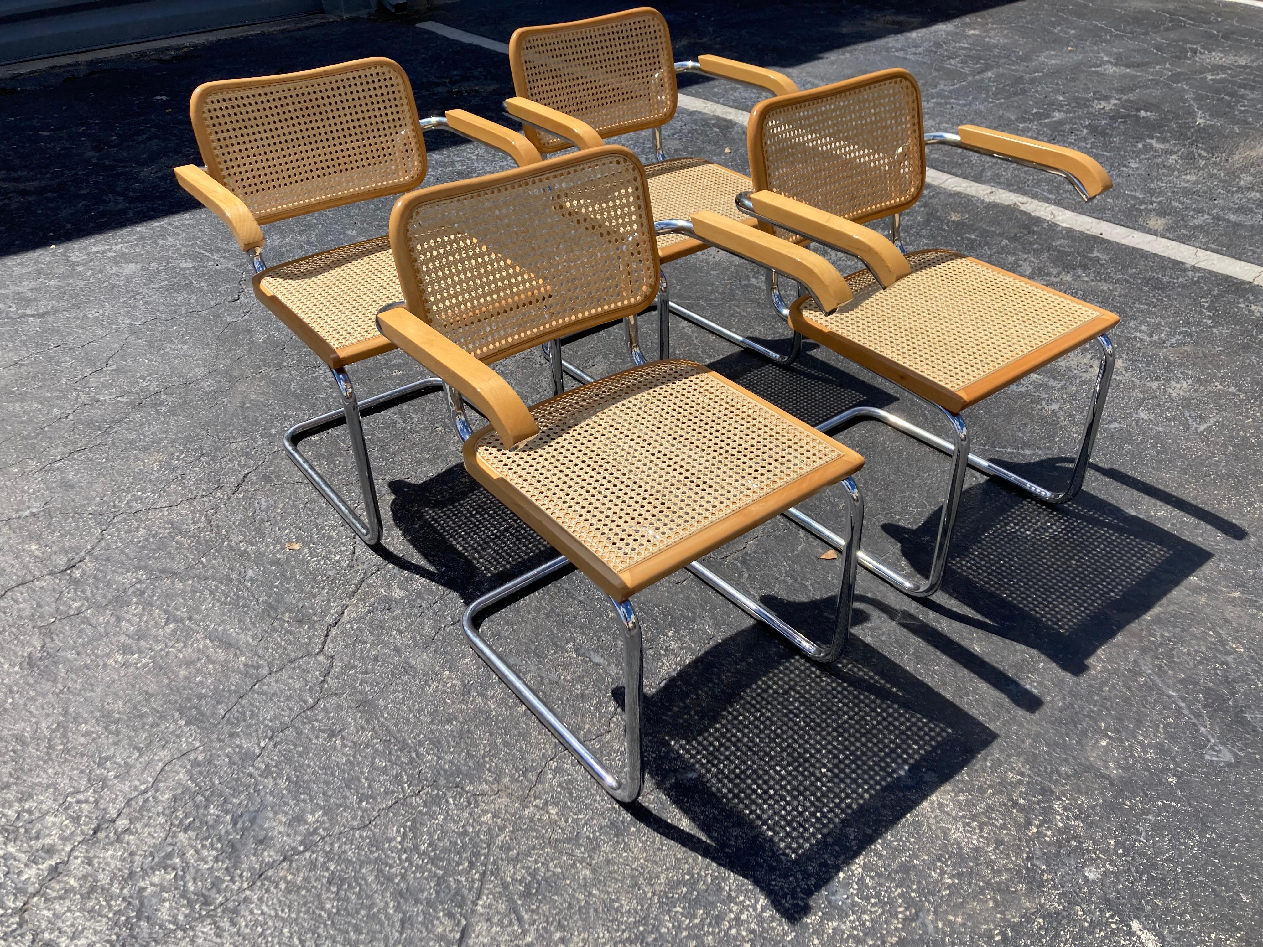 Set of four Marcel Breuer cesca chairs, made in Italy. Measures : Front arm height is 27”. 
Good used condition with some scratches and nicks.