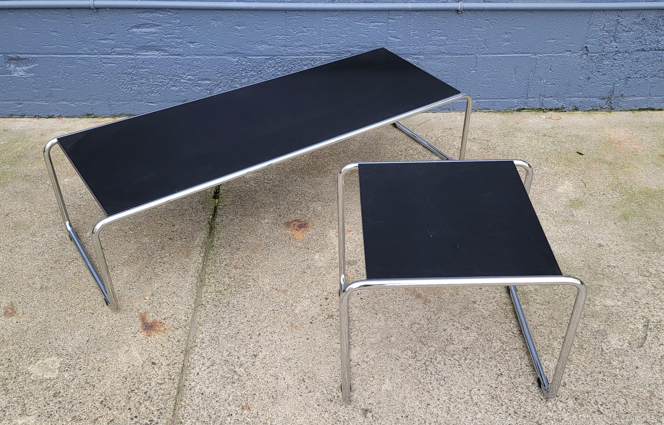 A coffee table and side table attributed to Marcel Breuer for Knoll. (labels missing). Black laminate table tops with polished chrome bases. All glides intact. Chrome in excellent condition, scuffs and scratches to table tops. Side table measures