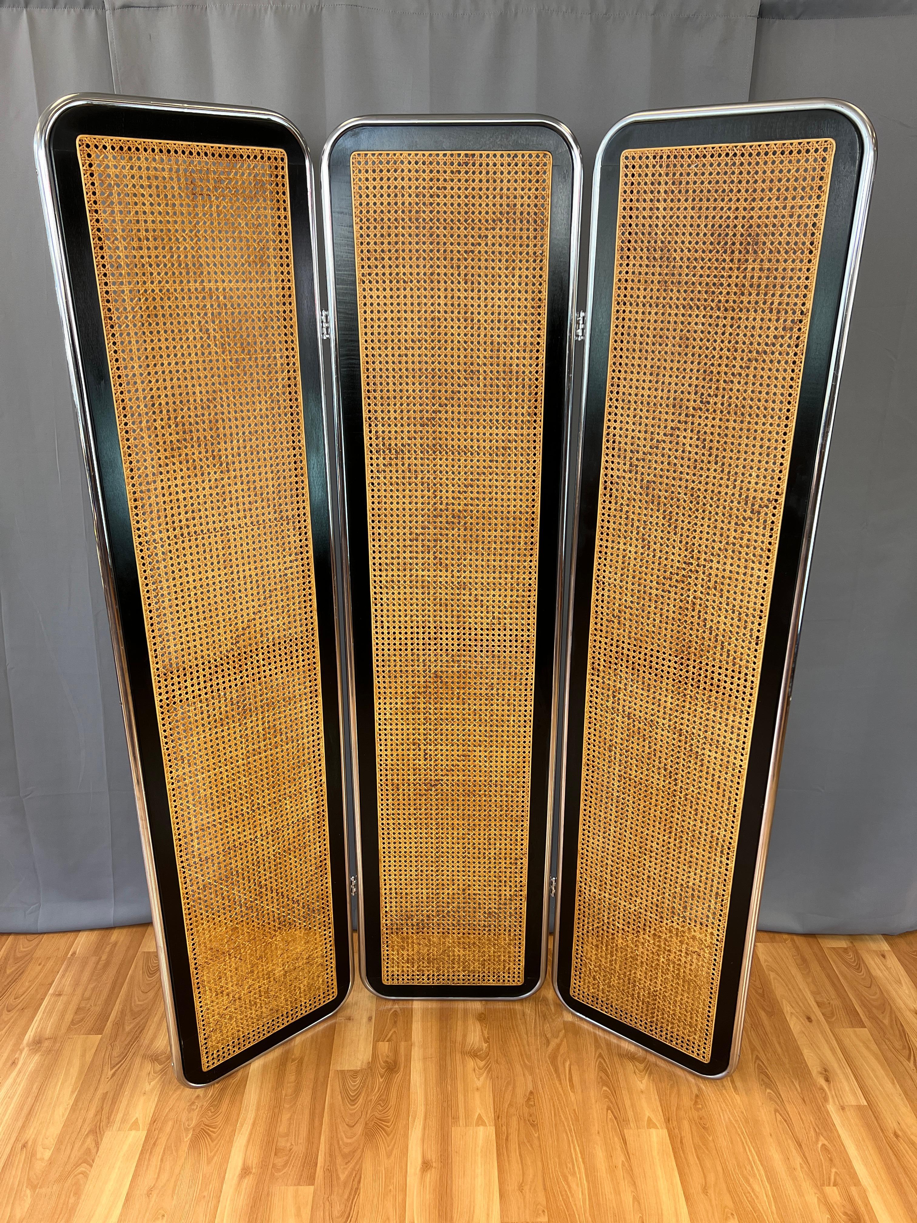 Offered here is a vintage Marcel Breuer style 3 panel rattan room divider and/or screen.
Three chromed metal tube frames, within those a rattan cane framed by a black painted wood.
Panels are held together by four hinges.

Each panel is about 18