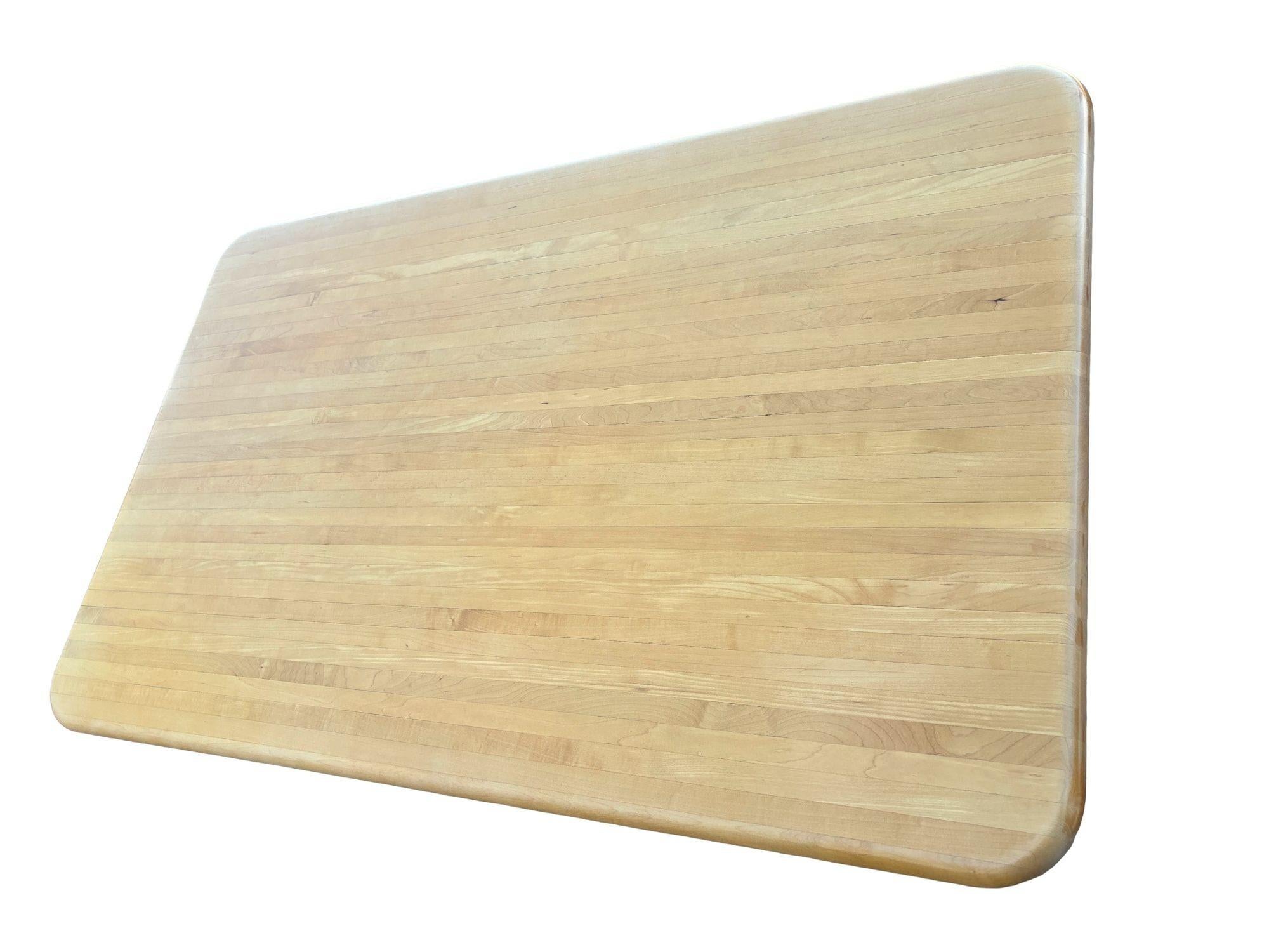 Un elegante tavolo da pranzo Mid-Century Modern ispirato agli iconici design Bauhaus di Marcel Breuer. Il tavolo presenta un piano rettangolare in legno biondo restaurato con bordi arrotondati e gambe tubolari cromate lucide. Questo pezzo