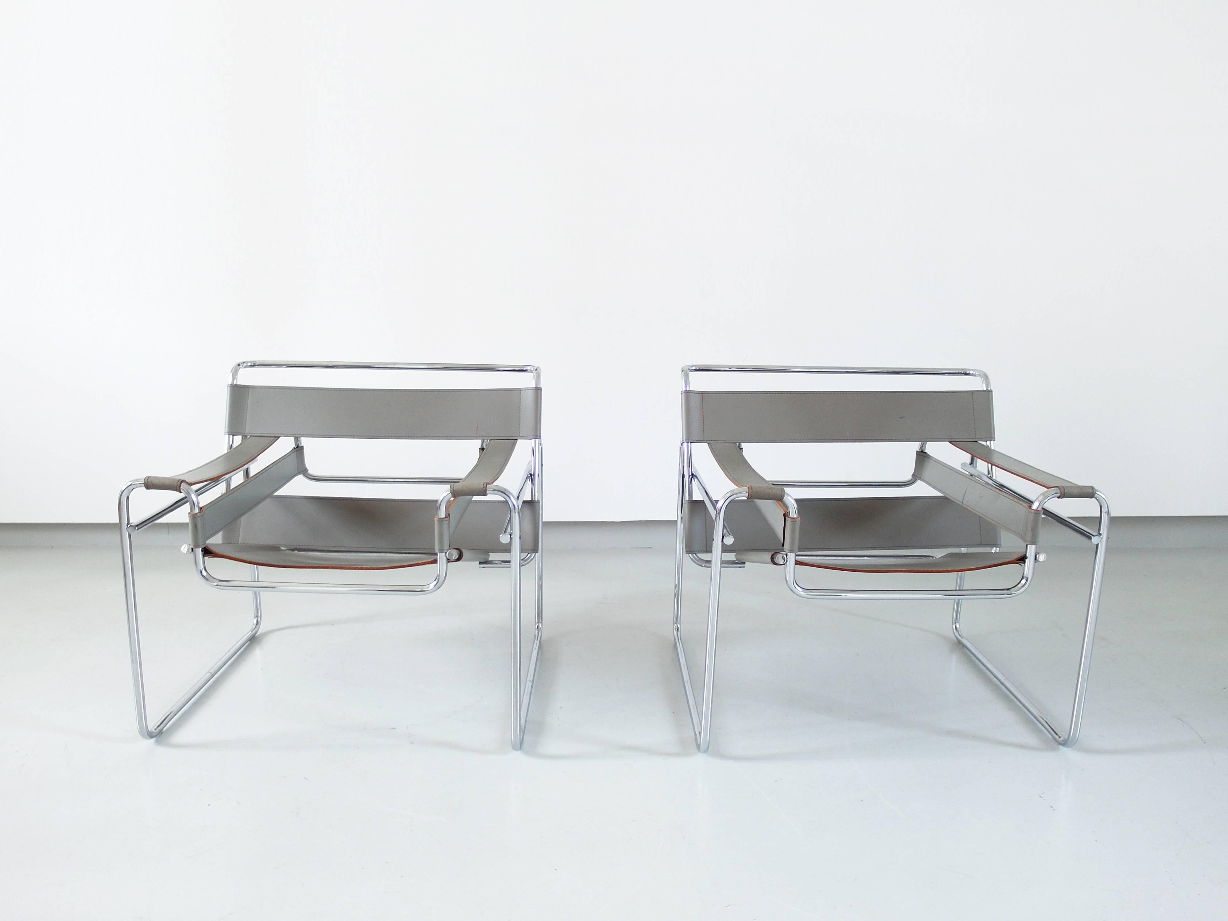 A pair of grey leather Wassily chairs, designed in 1925 by Marcel Breuer and manufactured by Knoll, circa 1980.
Inspired by the frame of a bicycle and influenced by the constructivist theories of the De Stijl movement, Marcel Breuer was still an